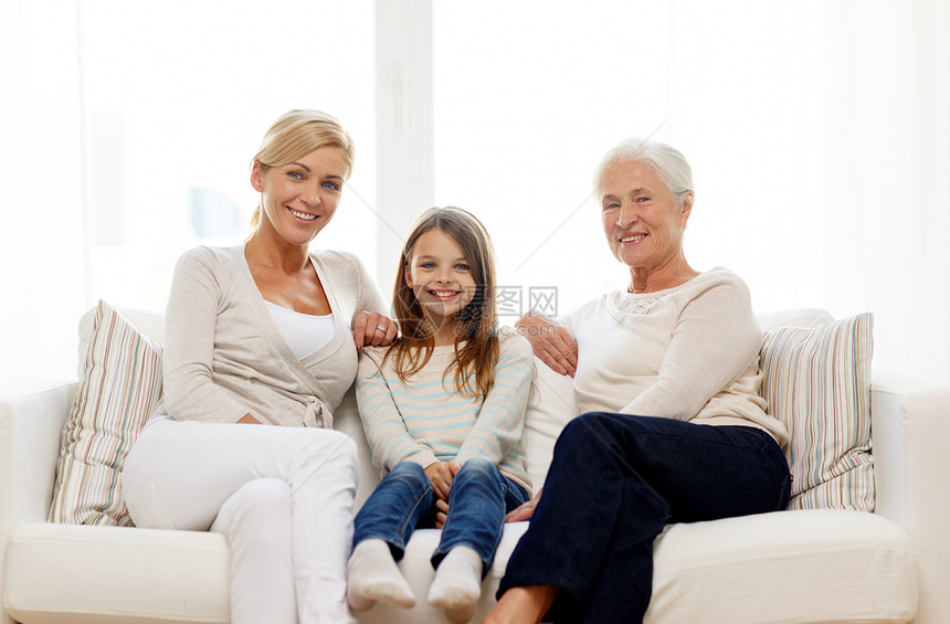 家庭幸福世代人的微笑的母亲女儿祖母坐家里的沙发上图片
