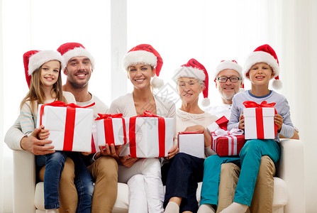 家庭,幸福,代,假日人们的幸福的家庭诞老人帮手帽子与礼品盒坐沙发上家图片