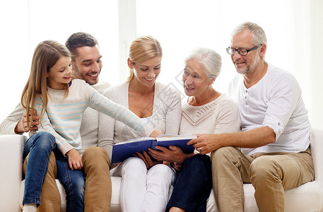 家庭,幸福,世代人的幸福的家庭与书相册坐沙发上家图片