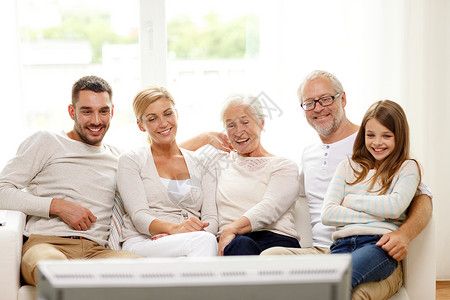 家庭,幸福,世代人的幸福的家庭坐沙发上,家看电视图片