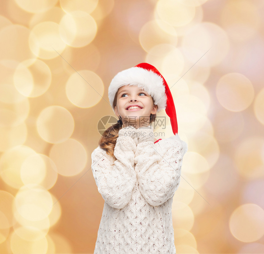 诞节,假日,童人的微笑的女孩诞老人帮助帽子米色灯光背景图片