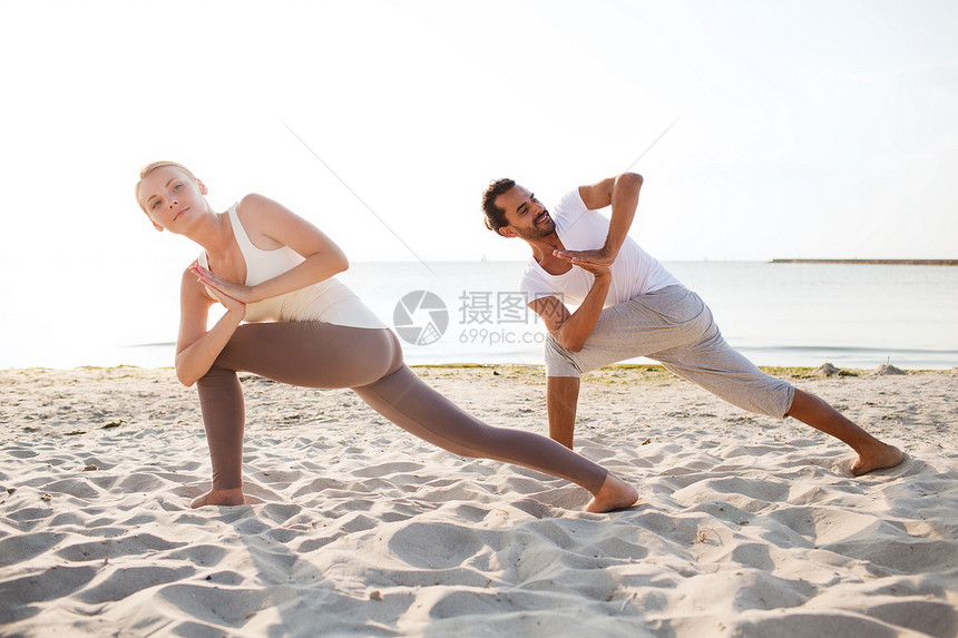 健身,运动,友谊生活方式的夫妇海滩上瑜伽练图片