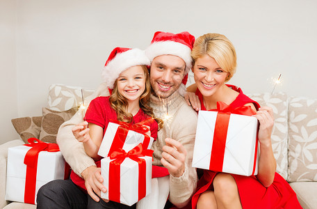 关棍节家庭,诞节,冬天,幸福人的微笑的家庭诞老人助手帽子与许多礼品盒孟加拉灯背景