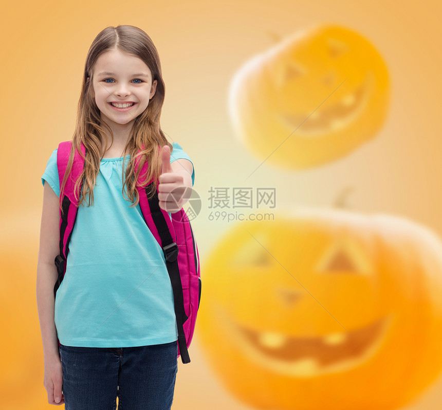 教育,假期,童,手势人的微笑的小女孩与背包拇指万节南瓜背景图片