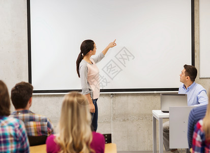教育高中技术人的微笑的学生女孩站白板前,老师教室里着笔记本电脑图片