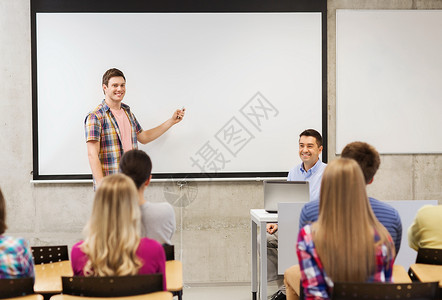 教育高中技术人的微笑的学生男孩,遥控器,笔记本电脑站白板前,老师教室里图片