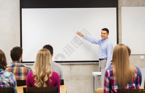 教育高中队合作人的微笑的老师站学生前,教室的白板上展示些东西背景