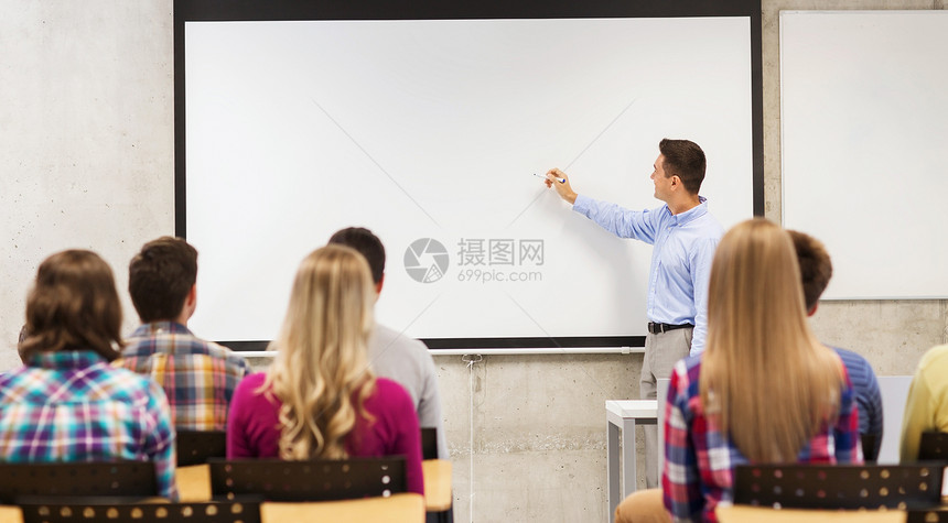 教育,高中,队合作人的微笑的老师站学生前,教室的白板上写些东西图片