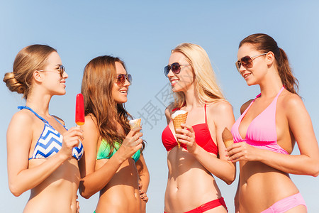 暑假,假期,食物,旅行人们的群微笑的轻女海滩上吃冰淇淋图片
