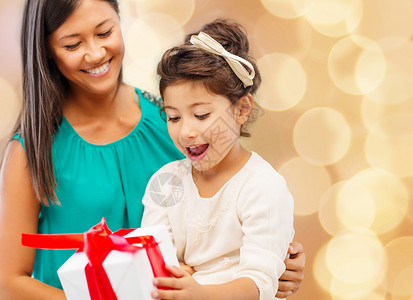 诞节,假日,庆祝,家庭人的快乐的母亲小女孩与礼品盒米灯光背景图片