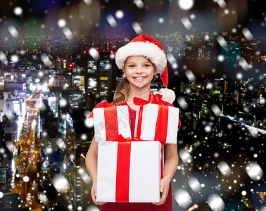 节日,礼物,诞节,童人的微笑的小女孩诞老人帮助帽子与礼品盒雪夜城市背景图片