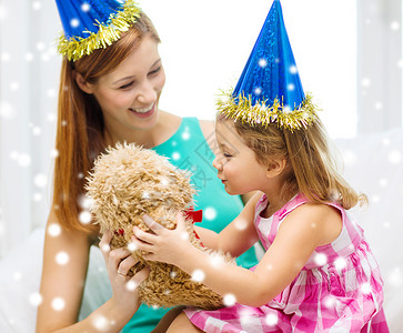 家庭,童,假期人的快乐的母亲女儿戴着蓝色的派帽泰迪熊玩具图片