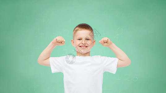 童,手势,教育,广告人的微笑男孩穿着白色T恤,绿色的木板背景上弯曲头肌图片