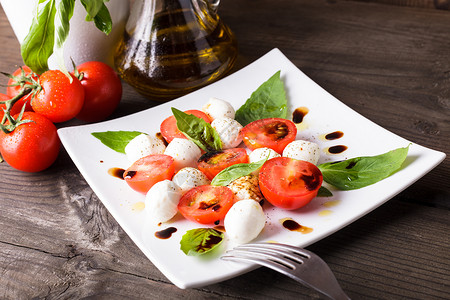 辣椒沙拉番茄,马苏里拉,罗勒叶与橄榄油香脂高清图片