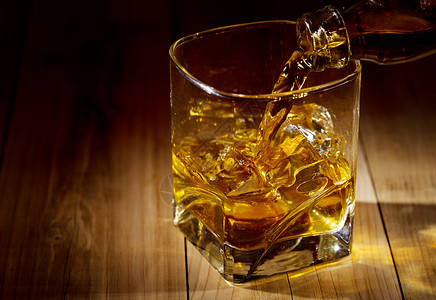 木制桌子上的杯威士忌背景图片