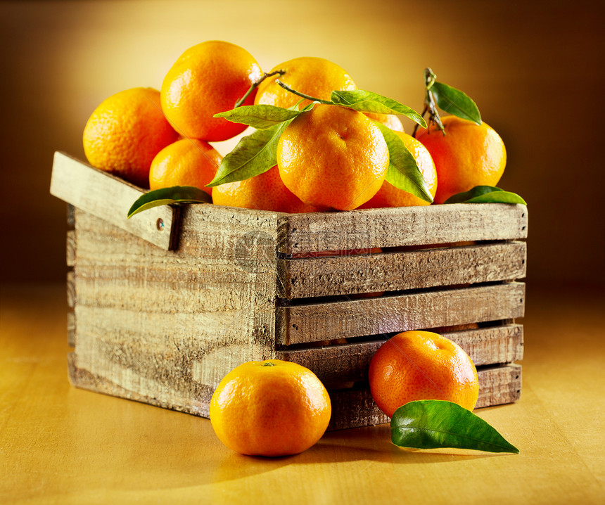 木制盒子里叶子的新鲜橘子图片
