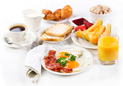 早餐包括煎鸡蛋咖啡橙汁牛角包烤包水果高清图片