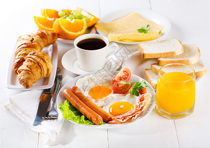 早餐包括煎鸡蛋牛角包果汁咖啡水果高清图片