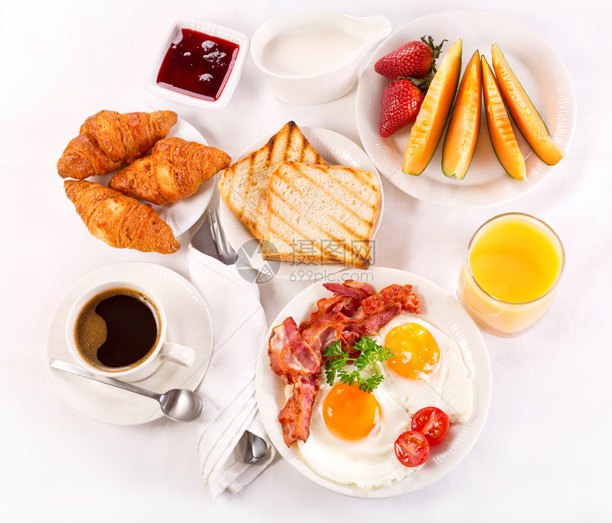 早餐包括煎鸡蛋咖啡橙汁牛角包烤包水果图片