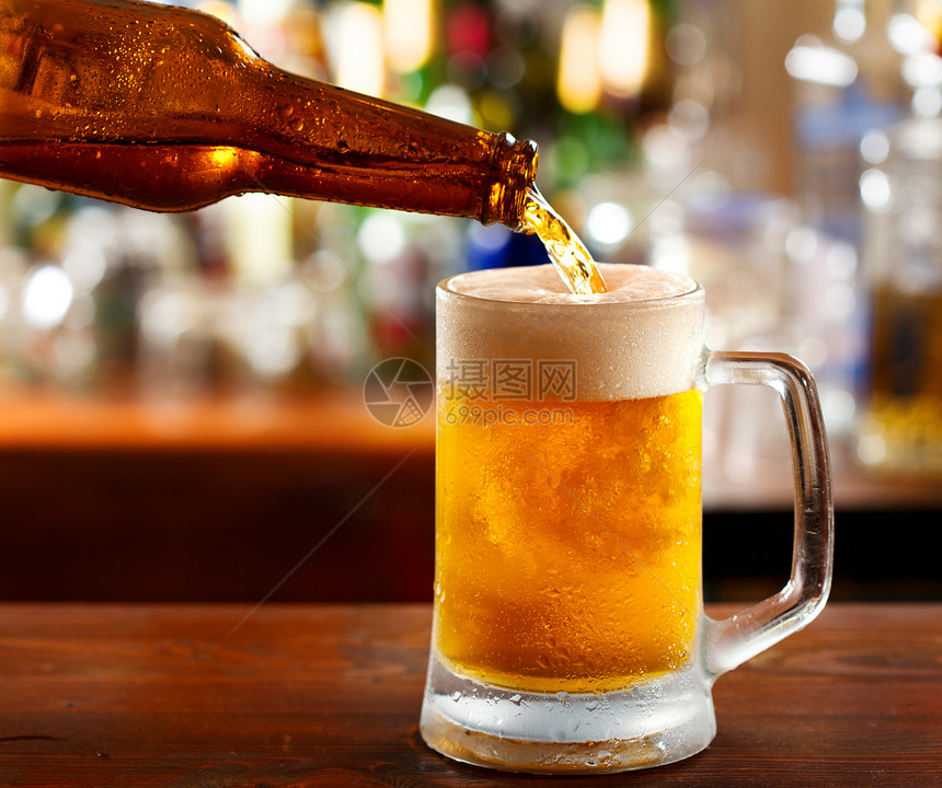啤酒倒进酒吧的杯子里图片
