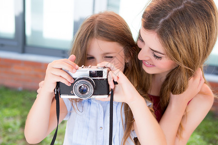 小女孩她的母亲妹妹用老式相机拍摄高清图片
