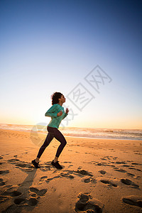 轻的阿夫罗女人海滩上跑步图片