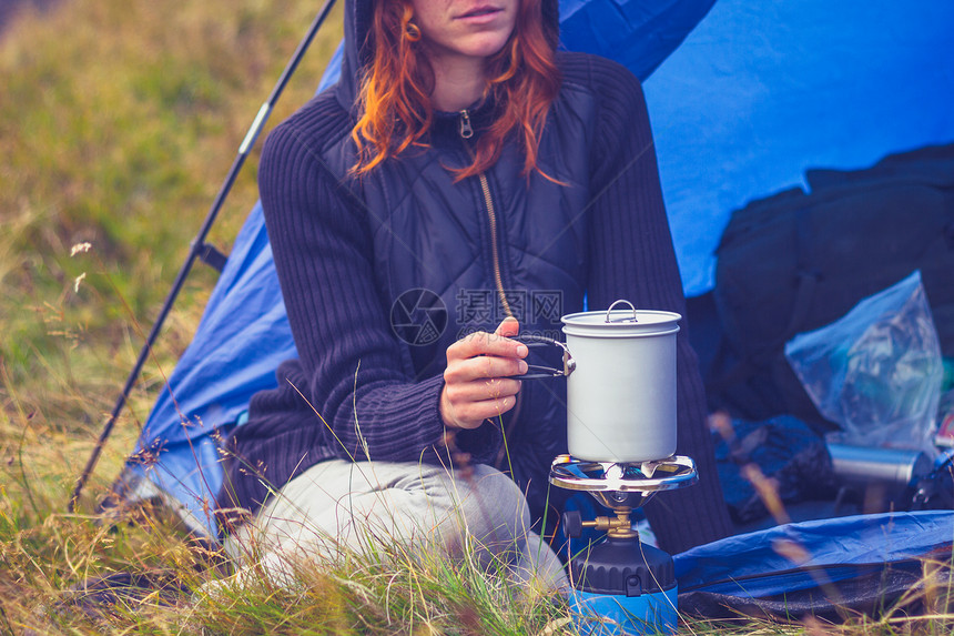 女人用便携式炉子露营饭图片