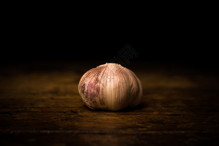 木制表黑色背景上的大蒜背景图片