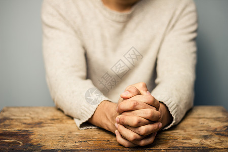 双手交叉祈祷的人图片