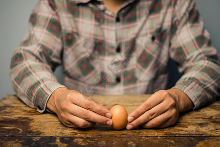 桌子上个鸡蛋的男人图片