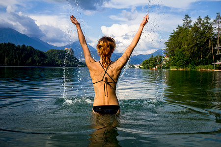 穿着泳装的轻女人站山湖里图片