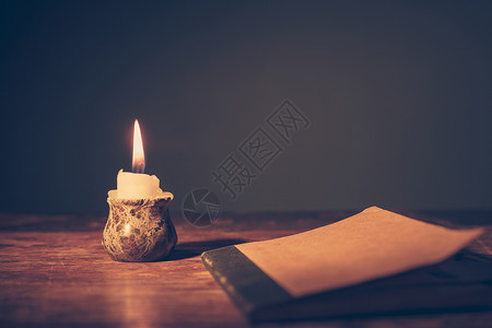 蜡烛旁边桌子上的个小笔记本高清图片