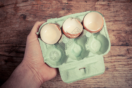 手鸡蛋手着盘鸡蛋壳桌子上背景