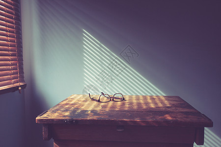 窗户边桌子上的眼镜,百叶窗上阴影背景图片