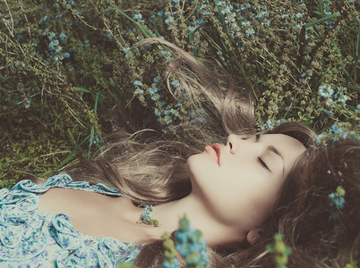 美丽的感女士躺花草地上图片