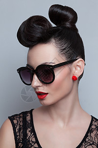 时尚太阳镜的时尚模特塑料皮肖像画红嘴唇向上,扭曲的高髻图片