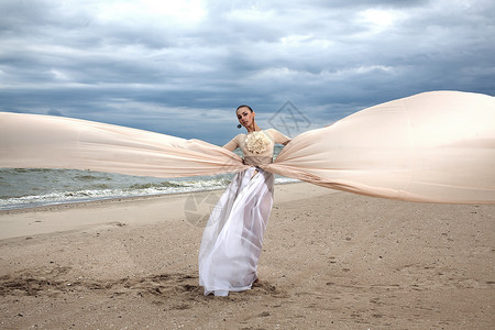 穿着长裙的模特就像海滩上的翅膀图片