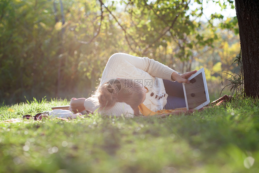 躺iPad屏幕上的女人晚上公园休息图片