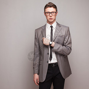 穿着灰色西装,手表眼镜的时尚男人图片
