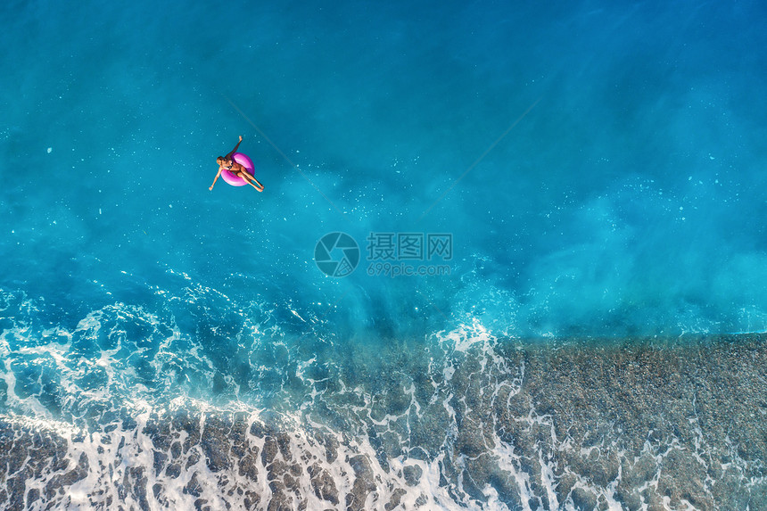 鸟瞰苗条的女人游泳粉红色的游泳环透明的绿松石海,土耳其的奥卢德尼斯夏天的海景与女孩,美丽的波浪,蓝色的水阳光明媚的日子图片