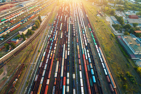 彩色货运列车的顶部视图火车站上五颜六色的货运列车的飞行无人机上俯瞰铁路上货物的货车重工业工业场景背景图片