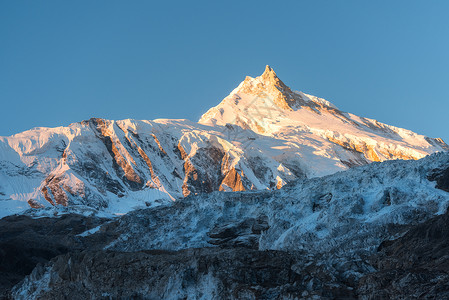 比利茨基高峰美丽的风景白雪覆盖的山五颜六色的日出尼泊尔风景与雪峰喜马拉雅山脉,冰川蓝天早上惊人的马纳斯鲁喜马拉雅山自背景