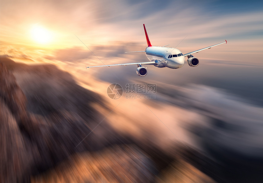 惊人的飞机Mith运动模糊效应日落时飞越低云风景与客机,模糊的云,山,太阳客机商务旅行商业飞机图片