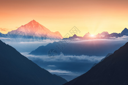 尼泊尔五颜六色的日出时,群山低云的轮廓的雄伟景象风景雪山的山峰,美丽的天空阳光岩石阳光自然背景图片