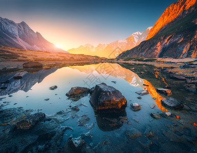 比利茨基高峰美丽的风景高山,明亮的山峰,山湖里石头,日出时倒影,蓝天阳光尼泊尔喜马拉雅山脉的惊人景象喜马拉雅山背景