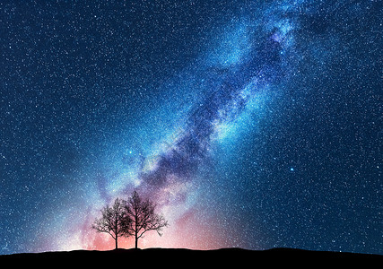 与银河抗星空的树木太空背景夜景观,山上只树木五颜六色明亮的银河神奇的星系自然与宇宙的美丽景象概背景图片