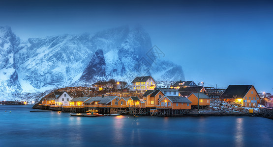 美丽的黄色买者房子萨基索伊村,洛福腾群岛,挪威冬季景观与传统的挪威罗布尔,海上,雪山雾中的夜晚老渔民的房子图片