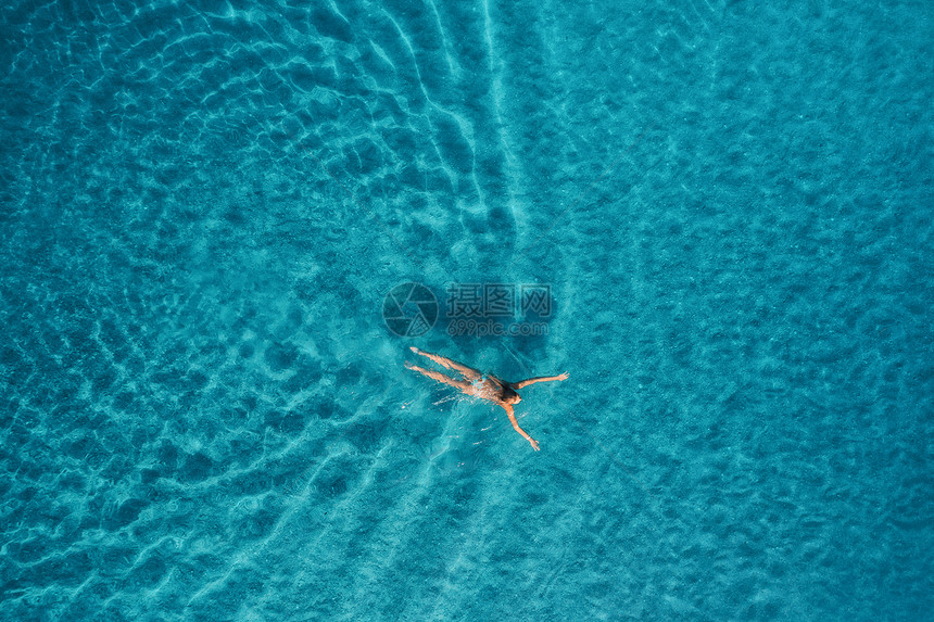 地中海游泳妇女的鸟瞰图马尔代夫日出时游泳妇女的鸟瞰图地中海夏天的海景与轻的女孩,清澈的蔚蓝的水,阳光明媚的早晨海图片