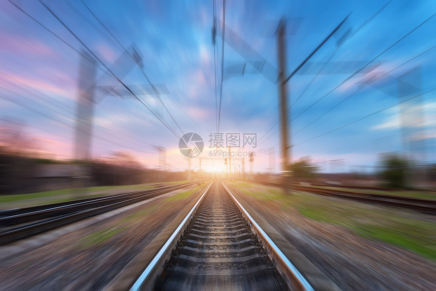 日落时运动模糊效果的火车站模糊的铁路工业景观与模糊的火车站,蓝天与彩色的云阳光铁路轨道背景运动模图片