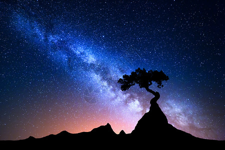 带蓝色银河的星空夜风景带蓝色银河的星空夜景观与孤独的树山峰上抗五颜六色的银河神奇的星系美丽宇背景图片